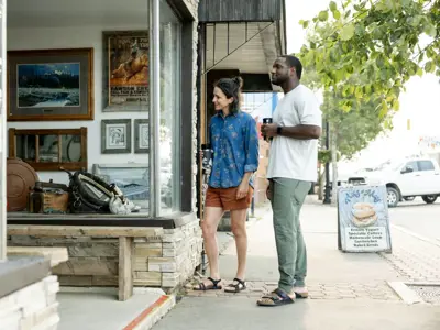 A photo of a man and a woman looking at a store window