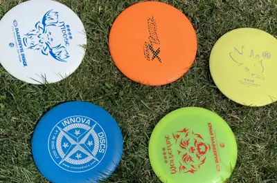 Photo of disc golf discs laying on grass