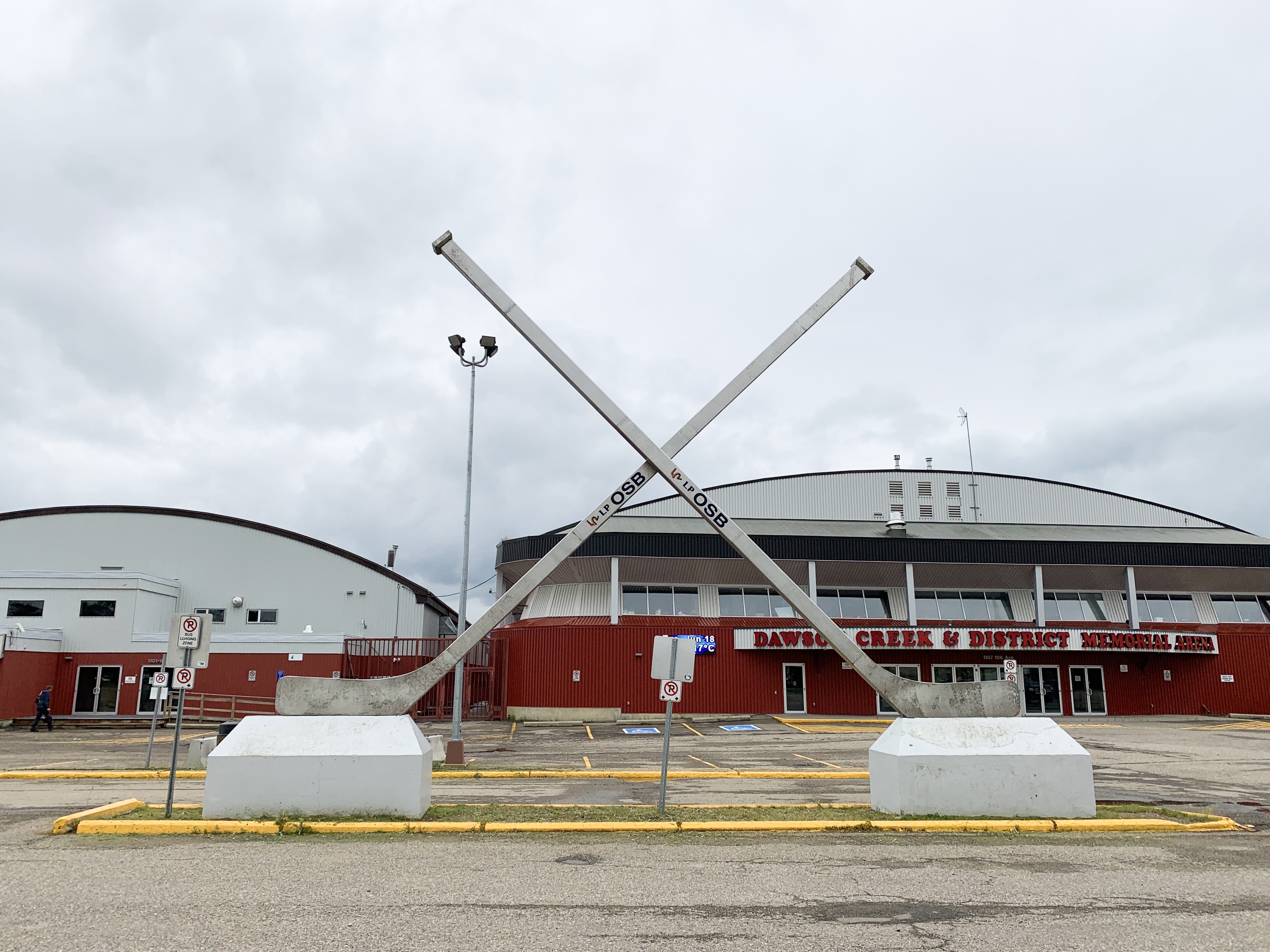 Photo of giant hockey sticks in a parking lot in front of an arena